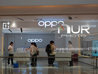 Customers experience mobile phones at an OPPO store in Shanghai, China, on October 18, 2024. (