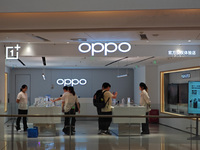 Customers experience mobile phones at an OPPO store in Shanghai, China, on October 18, 2024. (