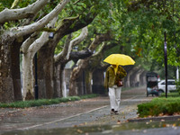 People wear thick clothes and walk in the rain in Qingzhou, China, on October 18, 2024. (