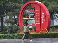 People wear thick clothes and walk in the rain in Qingzhou, China, on October 18, 2024. (