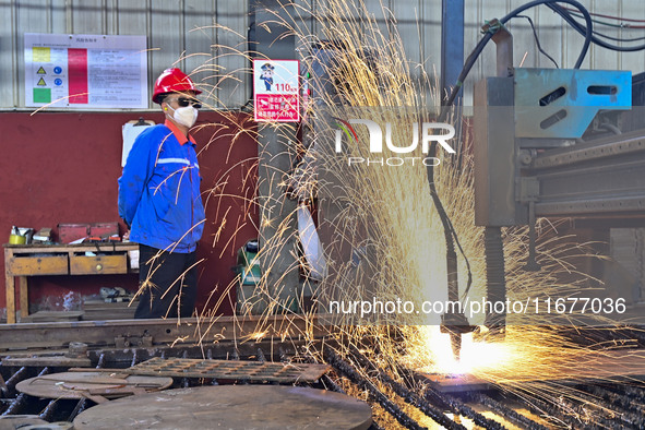 A worker works in a mechanical manufacturing enterprise in Qingzhou, China, on October 18, 2024. On the same day, the National Bureau of Sta...