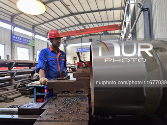 A worker works in a mechanical manufacturing enterprise in Qingzhou, China, on October 18, 2024. On the same day, the National Bureau of Sta...