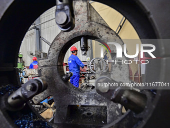 A worker works in a mechanical manufacturing enterprise in Qingzhou, China, on October 18, 2024. On the same day, the National Bureau of Sta...