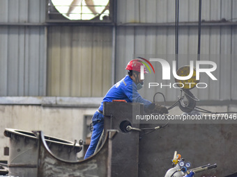 A worker works in a mechanical manufacturing enterprise in Qingzhou, China, on October 18, 2024. On the same day, the National Bureau of Sta...