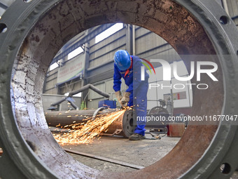 A worker works in a mechanical manufacturing enterprise in Qingzhou, China, on October 18, 2024. On the same day, the National Bureau of Sta...