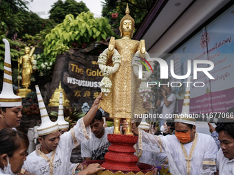 Thai Buddhist devotees dress as Thai angels and carry a statue of Lord Buddha to mark the end of the Buddhist Lent, known as 'Awk Phansa day...