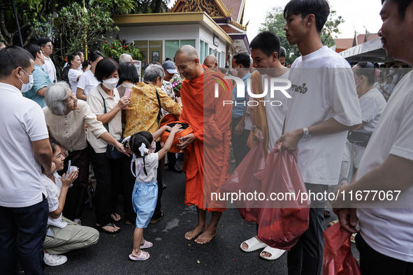 Buddhist devotees attend a morning alms ritual to mark the end of the Buddhist Lent, known as 'Awk Phansa day', at Golden Mount temple in Ba...