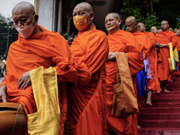 Thai Buddhist monks prepare for a morning alms ritual to mark the end of the Buddhist Lent, known as 'Awk Phansa day', at Golden Mount templ...