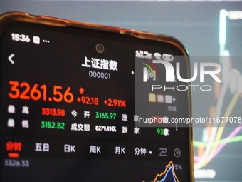 In Hangzhou, China, on October 18, 2024, a stockholder's mobile phone shows China's Shanghai Composite Index rising. (