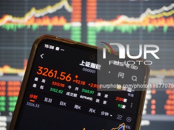 In Hangzhou, China, on October 18, 2024, a stockholder's mobile phone shows China's Shanghai Composite Index rising. (