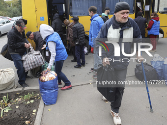 People from the Kupiansk community arrive at an evacuation point as mandatory evacuation from four communities in the Kharkiv region begins...