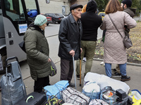 People from the Kupiansk community arrive at an evacuation point as mandatory evacuation from four communities in the Kharkiv region kicks o...