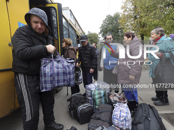 People from the Kupiansk community arrive at an evacuation point as mandatory evacuation from four communities in the Kharkiv region kicks o...