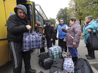 People from the Kupiansk community arrive at an evacuation point as mandatory evacuation from four communities in the Kharkiv region kicks o...