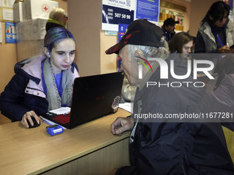 An elderly man receives help at an evacuation point during the arrival of people from the Kupiansk community in Kharkiv, Ukraine, on October...