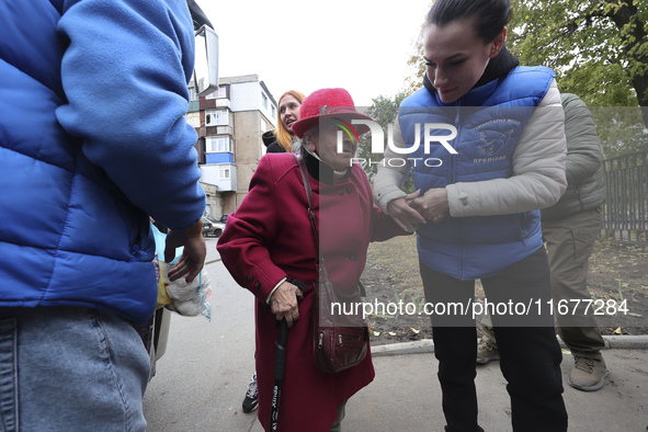 A volunteer supports an elderly woman at an evacuation point during the arrival of people from the Kupiansk community in Kharkiv, Ukraine, o...