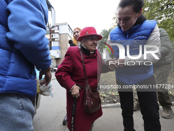 A volunteer supports an elderly woman at an evacuation point during the arrival of people from the Kupiansk community in Kharkiv, Ukraine, o...