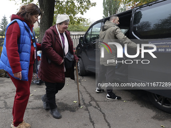 A volunteer accompanies an elderly woman at an evacuation point during the arrival of people from the Kupiansk community in Kharkiv, Ukraine...