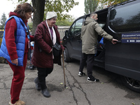 A volunteer accompanies an elderly woman at an evacuation point during the arrival of people from the Kupiansk community in Kharkiv, Ukraine...