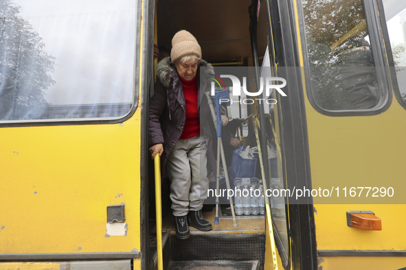 An elderly woman with crutches gets out of a bus at an evacuation point during the arrival of people from the Kupiansk community in Kharkiv,...