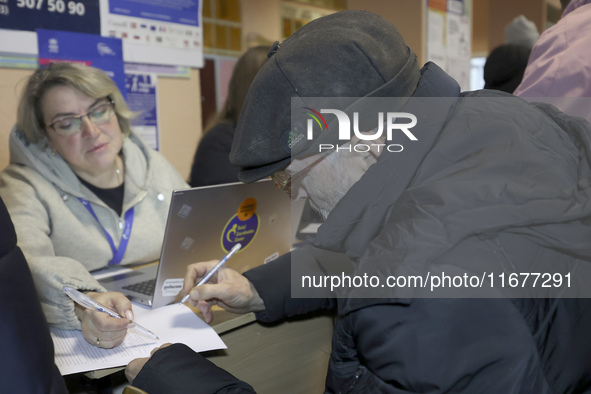 An elderly man receives help with papers at an evacuation point during the arrival of people from the Kupiansk community in Kharkiv, Ukraine...