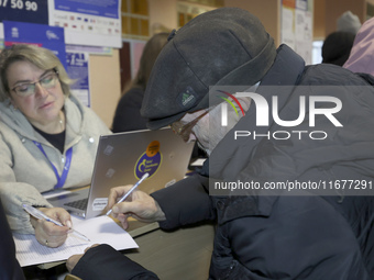 An elderly man receives help with papers at an evacuation point during the arrival of people from the Kupiansk community in Kharkiv, Ukraine...