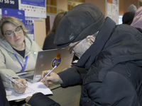 An elderly man receives help with papers at an evacuation point during the arrival of people from the Kupiansk community in Kharkiv, Ukraine...