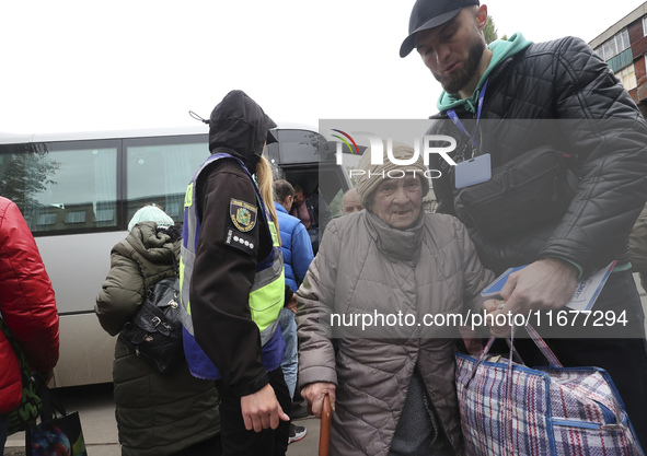 A volunteer supports an elderly woman at an evacuation point during the arrival of people from the Kupiansk community in Kharkiv, Ukraine, o...