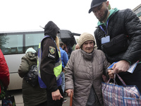 A volunteer supports an elderly woman at an evacuation point during the arrival of people from the Kupiansk community in Kharkiv, Ukraine, o...