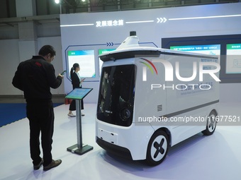 The audience visits the integrated unmanned delivery vehicle at the 2024 World Intelligent Connected Vehicle Conference in Beijing, China, o...