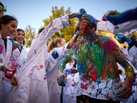 A first-year student from the Faculty of Medicine walks down a hall while seniors paint him with different colors and glitter as part of an...