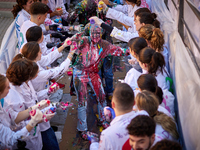 A first-year student from the Faculty of Medicine walks down a hall while seniors paint her with different color paints and glitter as part...