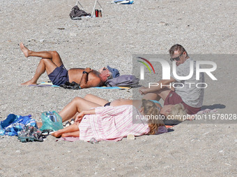 People enjoy the warm weather in Athens, Greece, on October 18, 2024. (