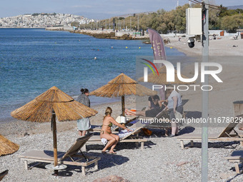 People enjoy the warm weather in Athens, Greece, on October 18, 2024. (