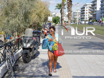 People enjoy the warm weather in Athens, Greece, on October 18, 2024. (