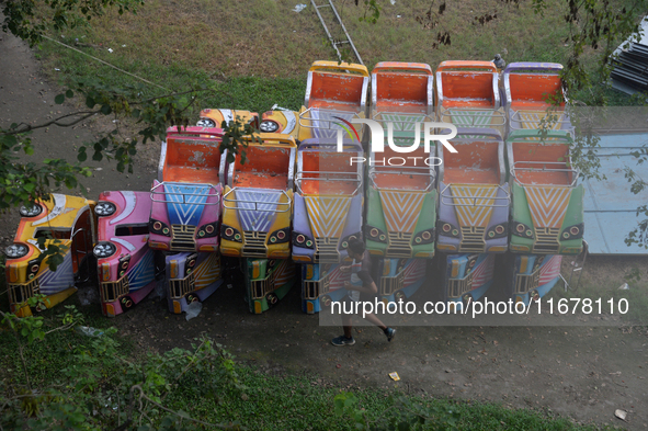 A boy runs past the toy cars placed for children to ride at a fair in Siliguri, India, on October 18, 2024. 