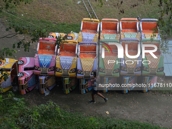 A boy runs past the toy cars placed for children to ride at a fair in Siliguri, India, on October 18, 2024. (