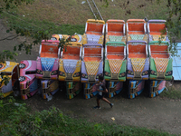 A boy runs past the toy cars placed for children to ride at a fair in Siliguri, India, on October 18, 2024. (