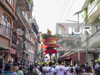 Nepalese Hindu devotees carry the chariot of Lord Satya Narayan during the Hadigaun Jatra festival in Kathmandu, Nepal, on October 18, 2024....