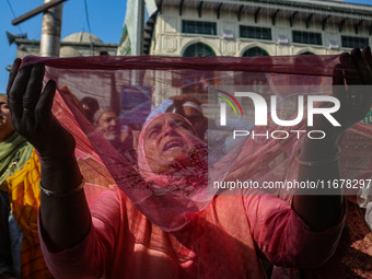 A Kashmiri Muslim devotee prays as a cleric displays a relic at the shrine of Sufi saint Sheikh Syed Abdul Qadir Jeelani, marking the last F...