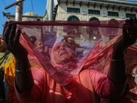 A Kashmiri Muslim devotee prays as a cleric displays a relic at the shrine of Sufi saint Sheikh Syed Abdul Qadir Jeelani, marking the last F...