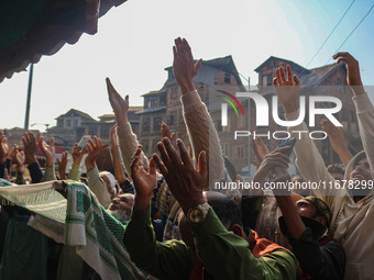 Kashmiri Muslim devotees pray as a cleric displays a relic at the shrine of Sufi saint Sheikh Syed Abdul Qadir Jeelani, marking the last Fri...