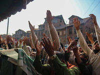 Kashmiri Muslim devotees pray as a cleric displays a relic at the shrine of Sufi saint Sheikh Syed Abdul Qadir Jeelani, marking the last Fri...