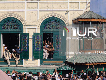 Kashmiri Muslim devotees pray as a cleric displays a relic at the shrine of Sufi saint Sheikh Syed Abdul Qadir Jeelani, marking the last Fri...