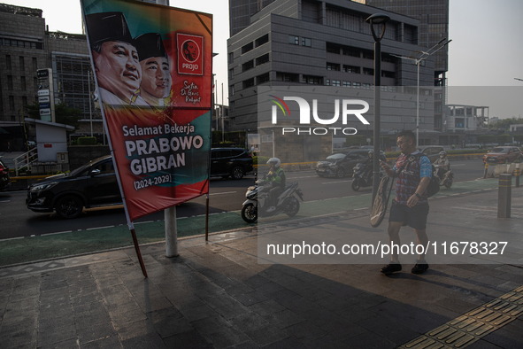 Vehicles pass by a banner that thanks President Joko Widodo and congratulates Indonesia's president-elect Prabowo Subianto and vice presiden...