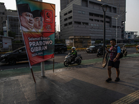 Vehicles pass by a banner that thanks President Joko Widodo and congratulates Indonesia's president-elect Prabowo Subianto and vice presiden...