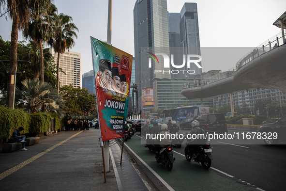 Vehicles pass by a banner that thanks President Joko Widodo and congratulates Indonesia's president-elect Prabowo Subianto and vice presiden...