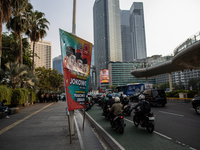 Vehicles pass by a banner that thanks President Joko Widodo and congratulates Indonesia's president-elect Prabowo Subianto and vice presiden...