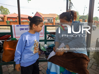 A Nepali health worker (R) records details of a child (L) before administering a ''Vitamin A'' capsule at an inoculation center in Kathmandu...