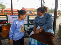 A Nepali health worker (R) records details of a child (L) before administering a ''Vitamin A'' capsule at an inoculation center in Kathmandu...